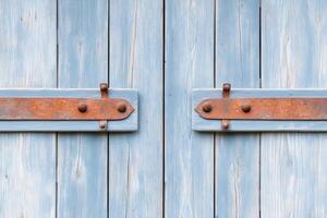 Old gray barn door with weathered textures and rusted hinges in a rural countryside setting photo