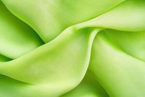 Vibrant folds of lime green fabric create dramatic texture and depth in textile design with elegant movement photo