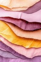 Layered pastel textiles and handmade paper samples create a tactile composition in dusty rose and warm gray tones photo