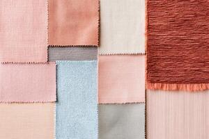 Layered pastel textiles and handmade paper samples in soft shades create an artistic tactile composition photo