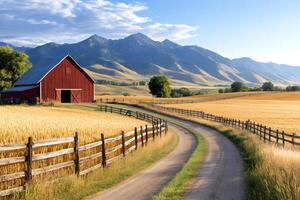 Red barn standing in golden field with mountains in background photo