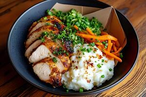 Sliced grilled chicken breast served with mashed potatoes, carrots and salad photo