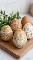 Easter eggs with folk geometric patterns resting on wooden cutting board photo