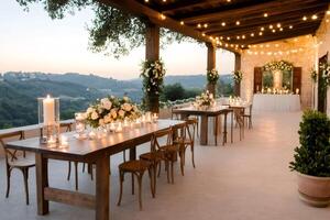 Wedding reception tables decorated with candles and flowers overlooking a valley at sunset photo