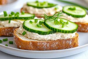 Chef preparing bread with cream cheese, cucumber and chives on toasted slices of baguette photo
