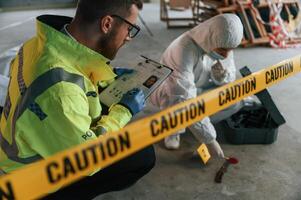 Caution ,police tape. Detectives are collecting evidence in a crime scene near dead body photo