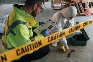 Caution, police tape. Detectives are collecting evidence in a crime scene near dead body photo