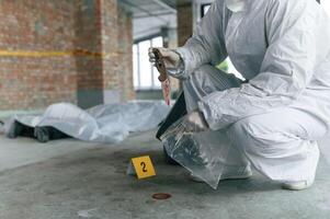 At daytime.. Detectives are collecting, evidence in a crime scene near dead body photo
