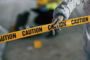 Close up view ,of caution police tape. Detectives are collecting evidence in a crime scene near dead body photo