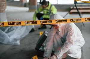 Caution police tape.. Detectives are collecting evidence in a crime scene near dead body photo