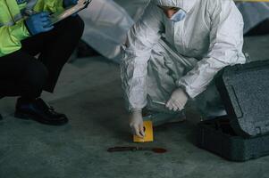 Detectives ,are collecting evidence, in a crime scene near dead body. Forensic specialists are making expertise photo
