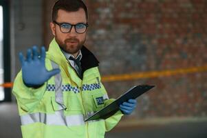 No, trespassing, stop gesture by a hand. Male detective is collecting evidence in a crime scene on the construction site photo