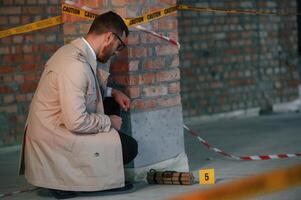 Detective in coat, is on the crime scene with explosive bomb photo