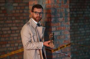 Detective in coat is on, the crime scene with explosive bomb photo