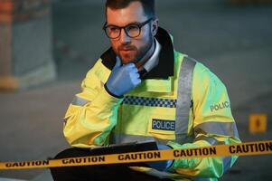Sitting and thinking. Male detective is collecting evidence in a crime scene on the construction site photo