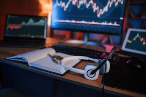 Computer with stock exchange, graph on display is in the dark room with neon lighting photo