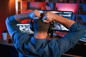 Man,is playing the shooter game on his computer. Neon lighting photo