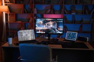Computer, with online first person shooter game launched. In dark room with neon lighting photo