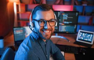 Professional programmer is working indoors,. Neon lighting photo