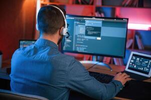Professional programmer is working ,indoors.. Neon lighting photo