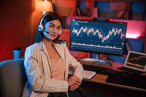 Female stock, trader is working by pc indoors. Conception of exchange and money photo