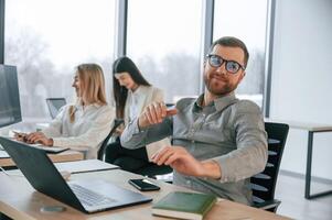 Man is, satisfied about results. Successful team are working together in the office. Conception of business photo