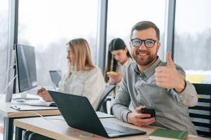 Front view of man.. Successfulm team are working together in the office. Conception of business photo