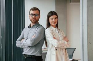 Man with woman is standing ,and posing.. Successful team are working together in the office. Conception of business photo
