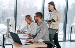 Using ,laptops... Successful team are working together in the office. Conception of business photo