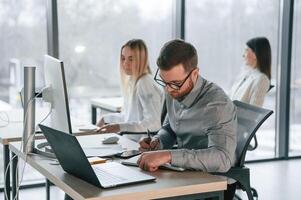 Using laptops. Successful team are working together in the office. Conception of business photo