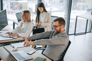 Man is satisfied about results. Successful team are working together in the office. Conception of business photo