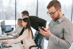 Side view, of man that is sitting. Successful team are working together in the office. Conception of business photo