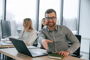 Front, view of man. Successful team are working together in the office. Conception of business photo