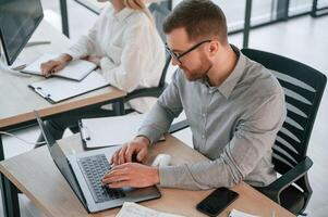 Side view of man, that is sitting. Successful team are working together in the office. Conception of business photo