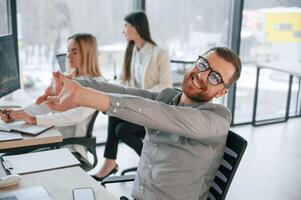 Man is satisfied, about results. Successful team are working together in the office. Conception of business photo