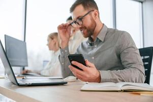 Side, view of man that is sitting. Successful team are working together in the office. Conception of business photo