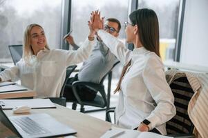 Doing high five.. Successful, team are working together in the office. Conception of business photo