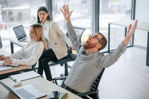 Man ism satisfied about results. Successful team are working together in the office. Conception of business photo