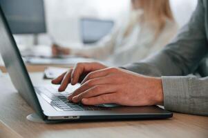 Close, up view, using laptop. Successful team are working together in the office. Conception of business photo