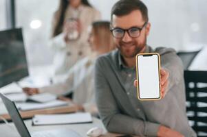 Close up view of smartphone. Copy space. Successful team are working together in the office. Conception of business photo