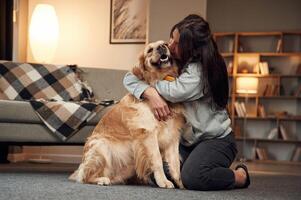 Kissing ,the dog. Woman is with golden retriever at home photo