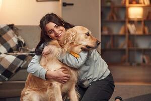 Woman is with golden retriever dog at home. photo