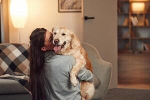 Woman is with golden retriever dog at home,, photo