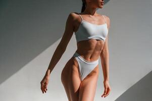 Showing new collection, of underwear. Young caucasian woman with slim body shape is indoors in the studio photo