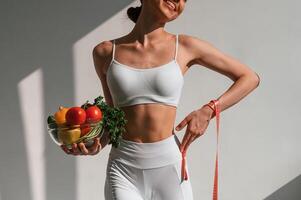 Conception, of diet. With ,vegetalbes and fruits. Young caucasian woman with slim body shape is indoors in the studio photo