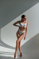 Tall ,figure. Young caucasian woman with slim body shape is indoors in the studio photo