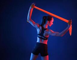 Beautiful ,muscula,r woman is indoors in the studio with neon lighting photo