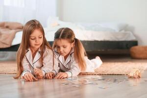 Card game. Two little girls are playing and having fun together in domestic room photo
