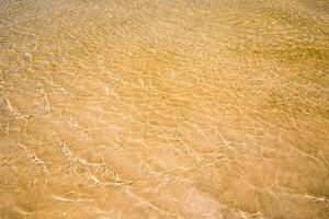 The Light reflection on the surface of movement sea on sand beach photo