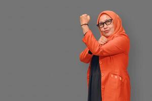 Confident Muslim woman in hijab showing strength pose with a smile photo